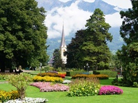 Herrliche Blütenpracht im Stadtpark von Bad Ragaz; im Hintergrund ragt der Turm der Reformierten Kirche auf.